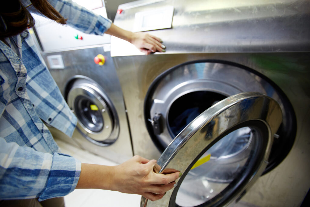 pessoa abrindo a máquina de lavar roupas