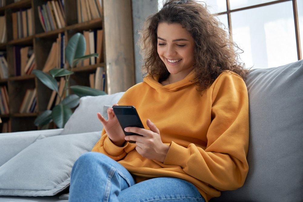 Mulher feliz navegando em seu smartphone.